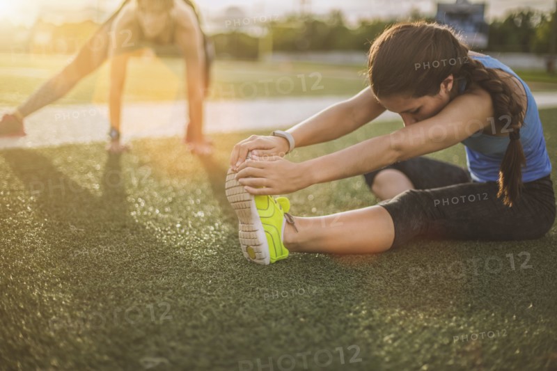 Athletes stretching on sports field