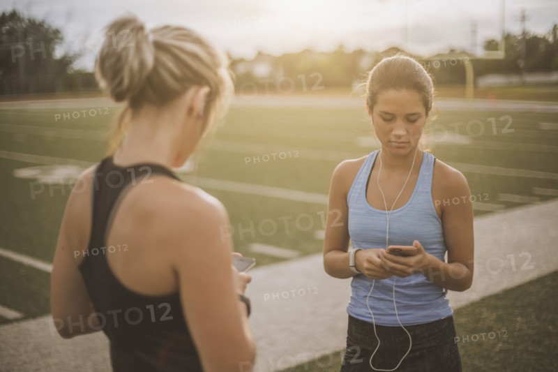 Athletes listening to mp3 players on sports field