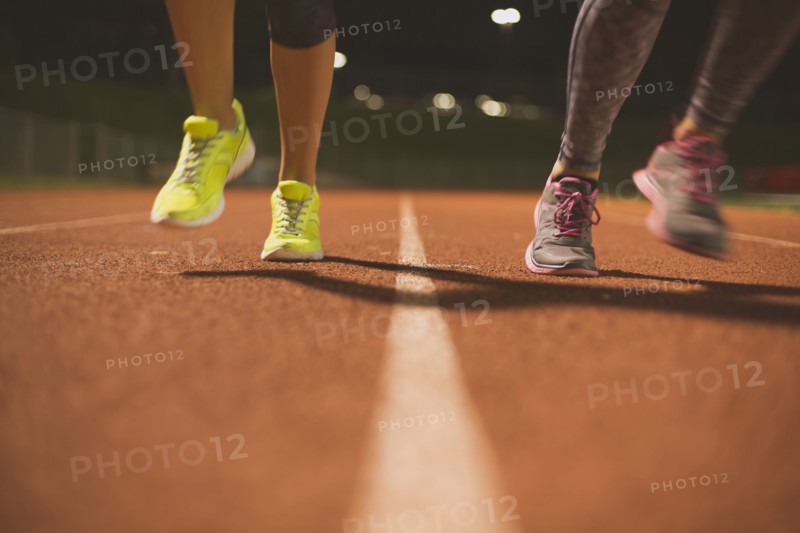 Athletes running on track on sports field