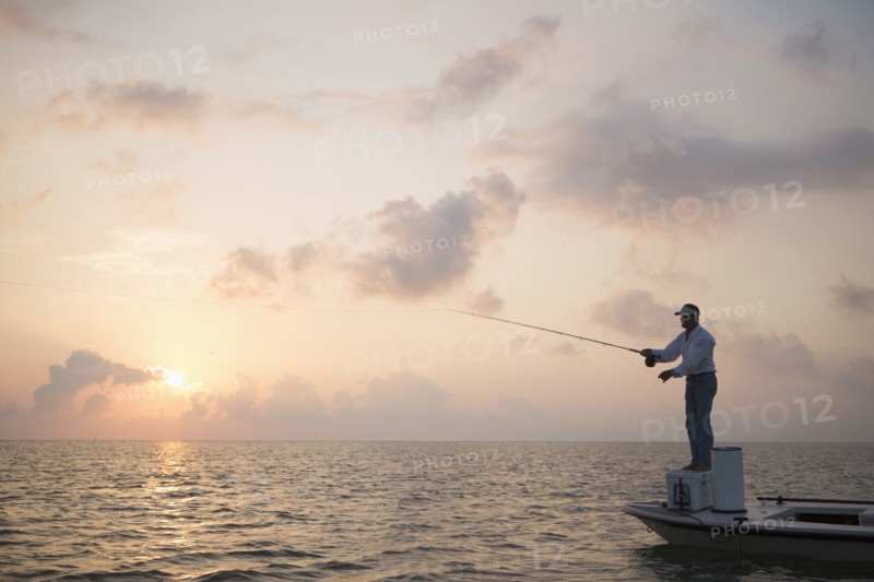 Caucasian man fishing on boat in ocean