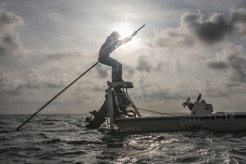 Caucasian fisherman rowing boat on ocean