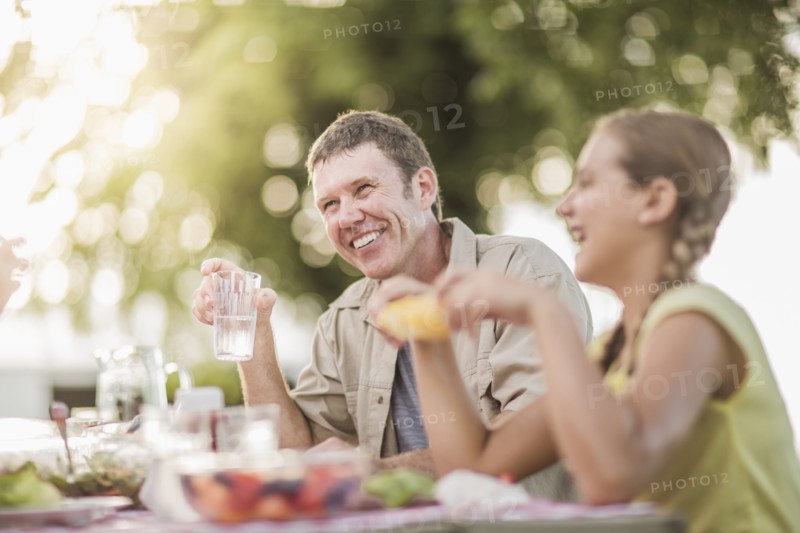 Caucasian family eating in backyard