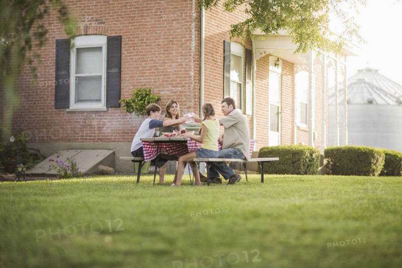 Caucasian family eating in backyard