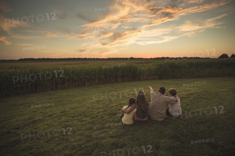 Caucasian family admiring corn fields at sunset
