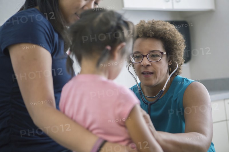 Doctor listening to chest of girl