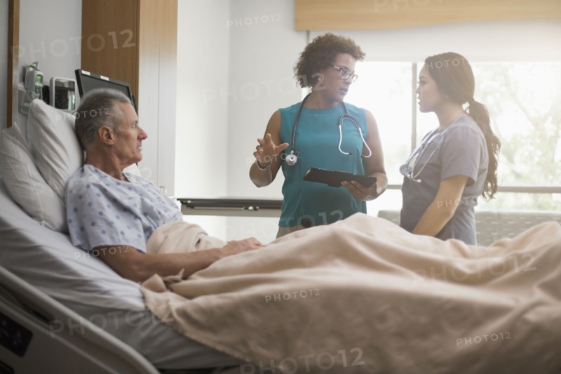 Doctor and nurse with patient in hospital room