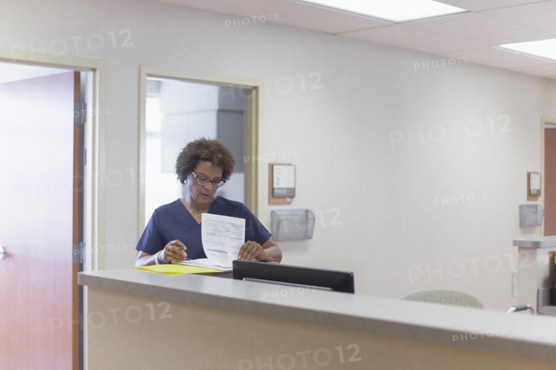 African American nurse writing in hospital