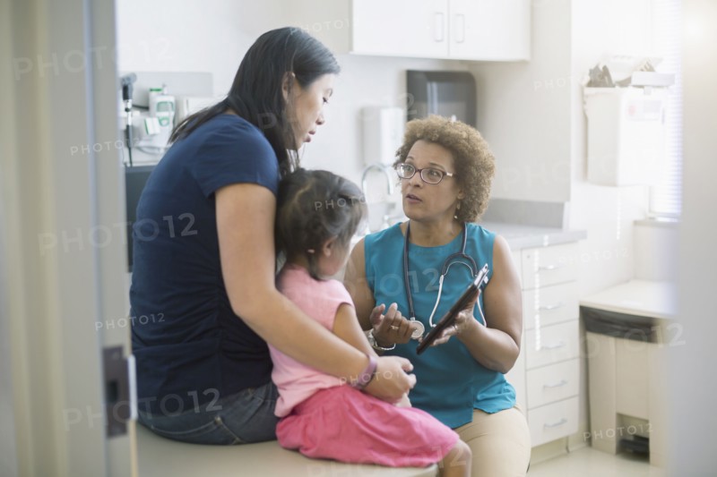 Doctor using digital tablet with patients