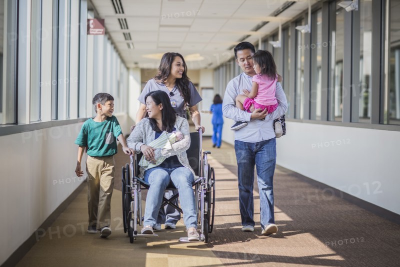 Nurse with patient and family in hospital hallway