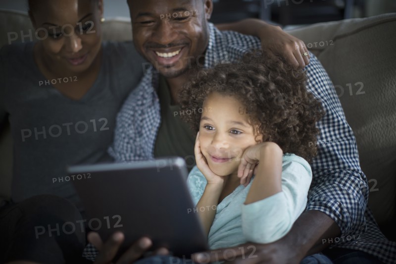Family using digital tablet on sofa