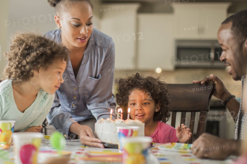 Girl admiring birthday cake at party