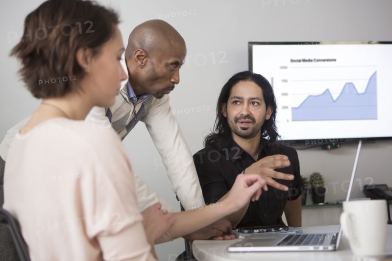 Business people using laptop in meeting