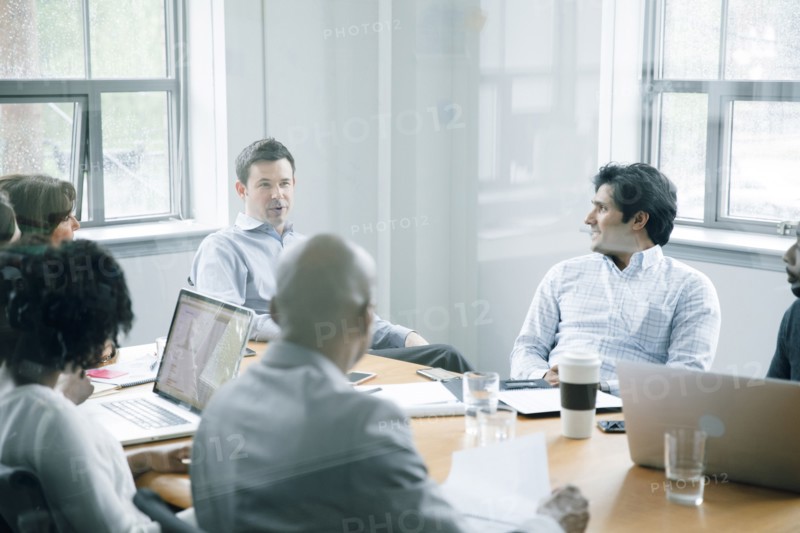 Business people talking behind window in meeting
