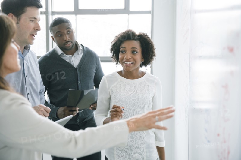 Business people talking near whiteboard in meeting