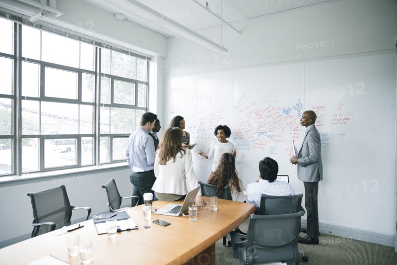 Businesswoman talking near whiteboard in meeting