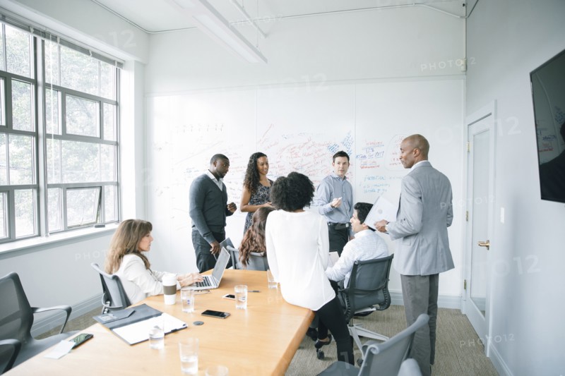 Businessman talking near whiteboard in meeting