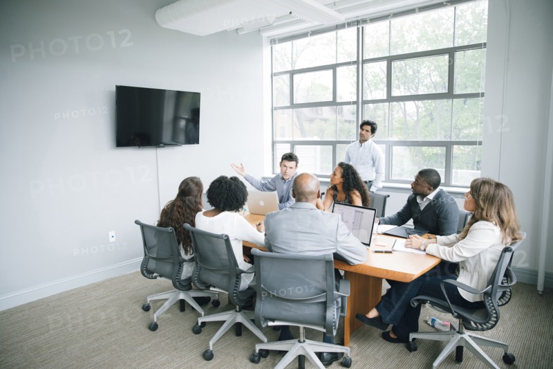 Businessman talking near visual screen in meeting