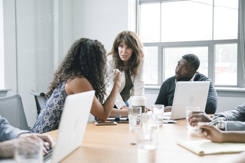 Business people using laptop in meeting