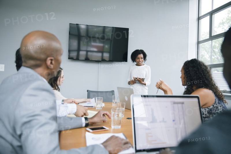 Businesswoman talking near visual screen in meeting