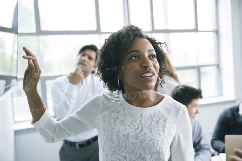 Businesswoman talking near visual screen in meeting