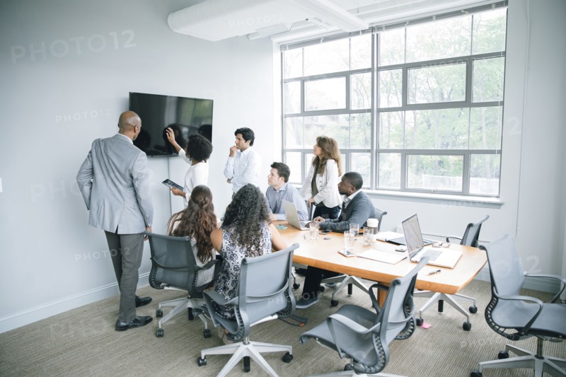 Businesswoman talking near visual screen in meeting