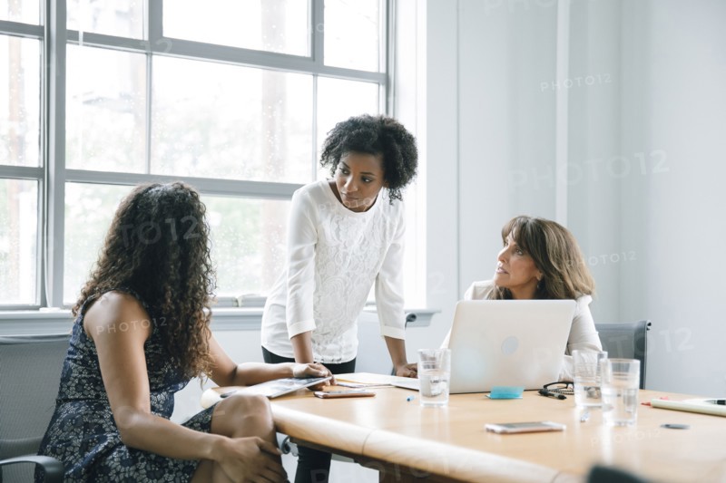 Businesswomen using laptop in meeting