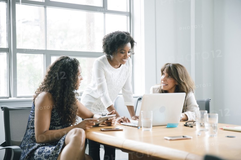 Businesswomen using laptop in meeting