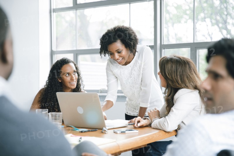 Businesswomen using laptop in meeting