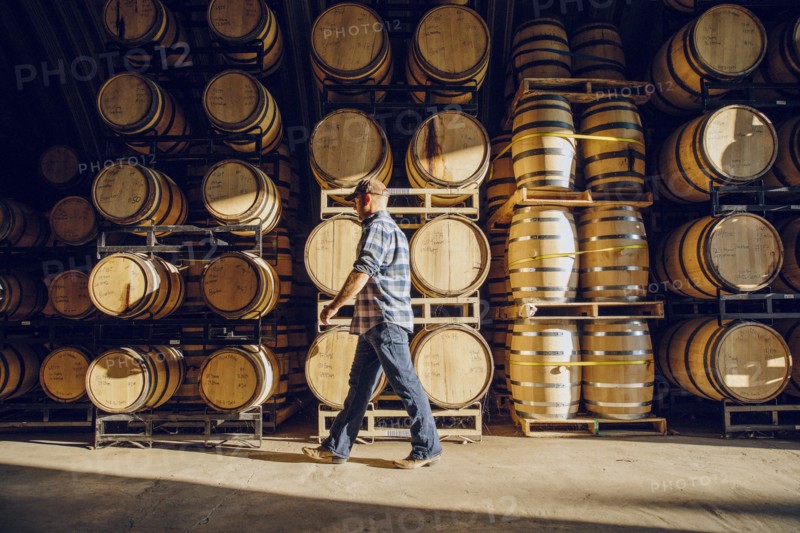 Caucasian man walking near barrels in distillery