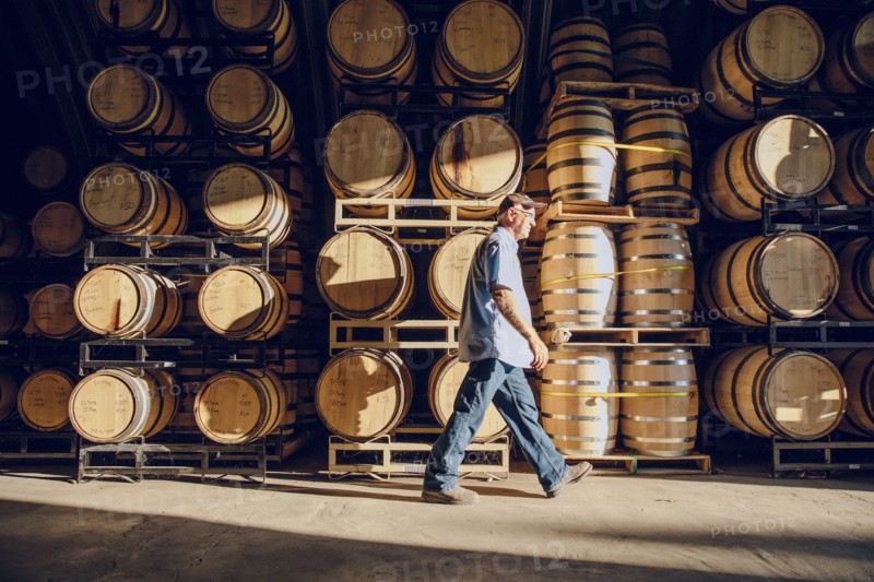 Caucasian man walking near barrels in distillery