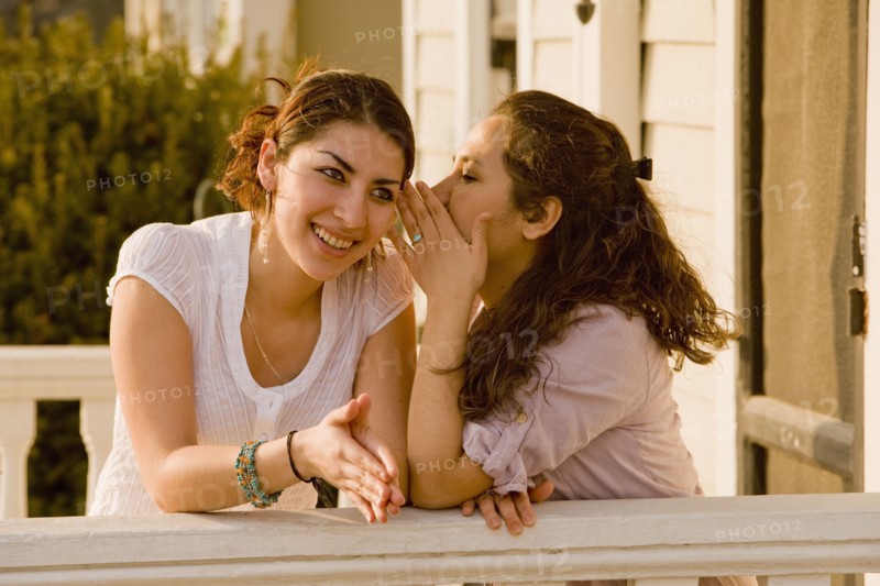 Hispanic women telling secret