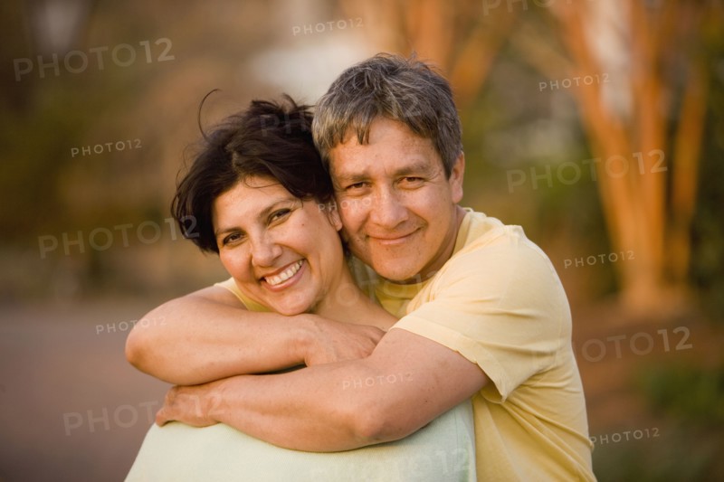 Hispanic couple hugging in park
