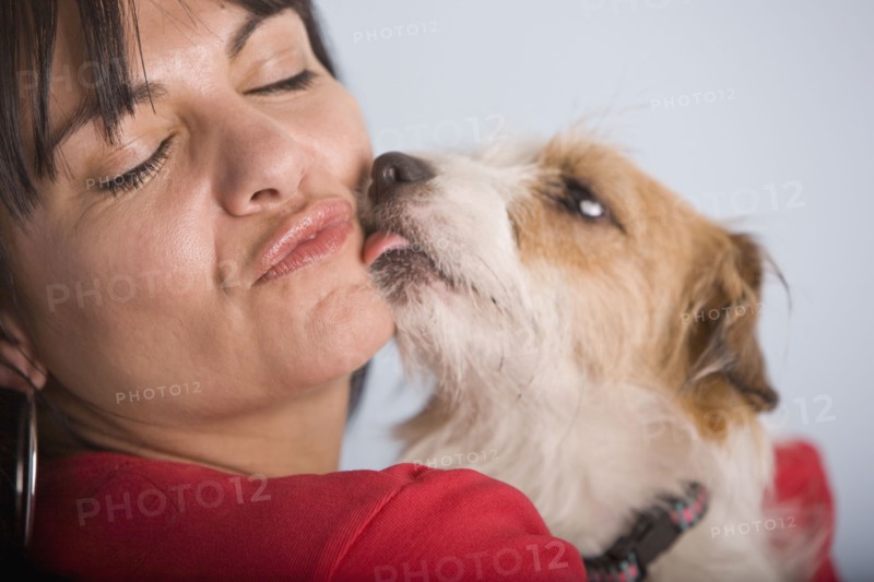 Dog licking Hispanic woman's face