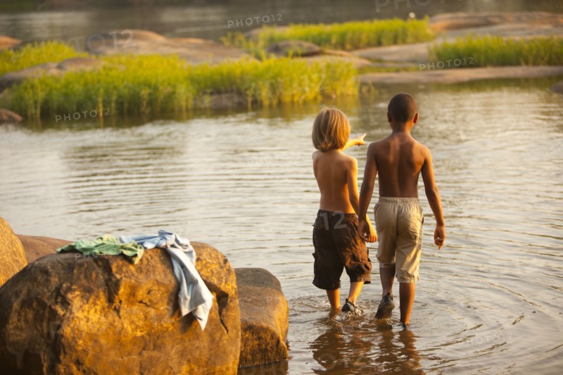 Boys wading in lake together