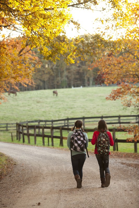 Caucasian girls walking together on road in countryside