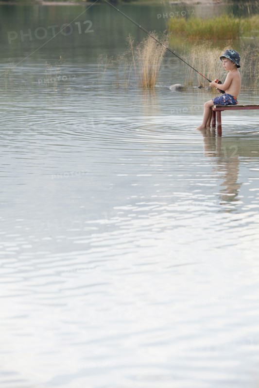 Caucasian boy fishing in lake