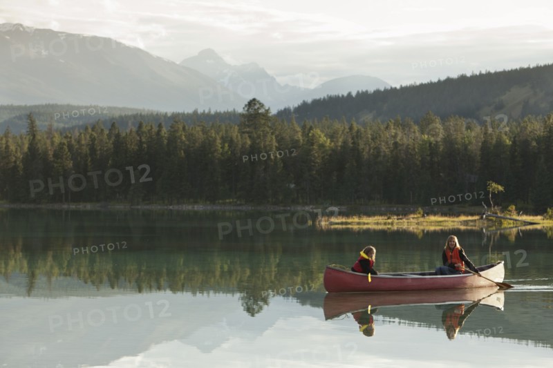 Caucasian mother and daughter canoeing on Lake Edith