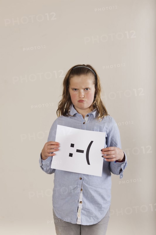 Caucasian boy holding card with sad face