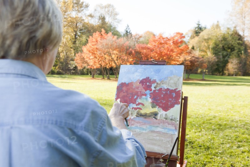Senior woman painting outdoors