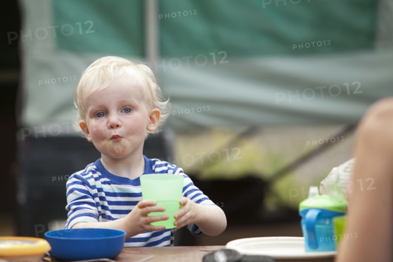 Caucasian boy eating at campsite