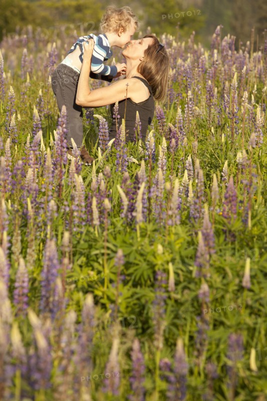 Caucasian mother kissing son in tall grass