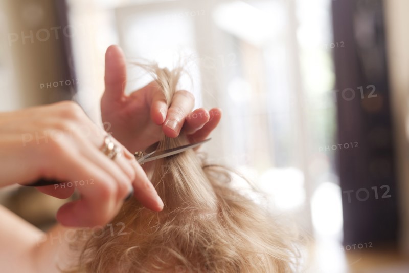 Caucasian mother cutting hair of son