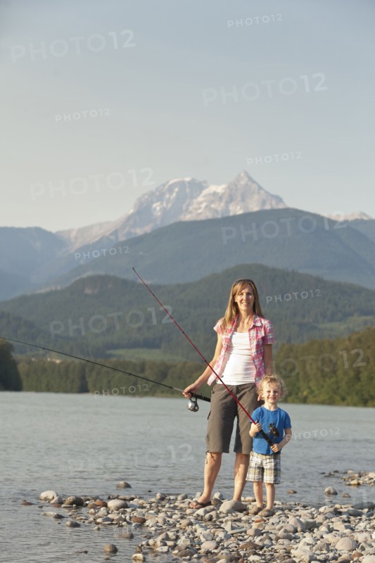 Caucasian mother and son fishing in remote lake