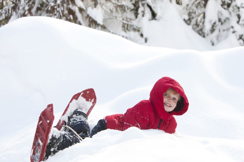 Caucasian boy snowshoeing on hillside