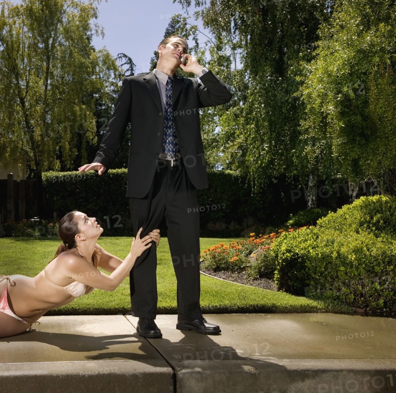 Hispanic woman in bikini grabbing businessman's leg