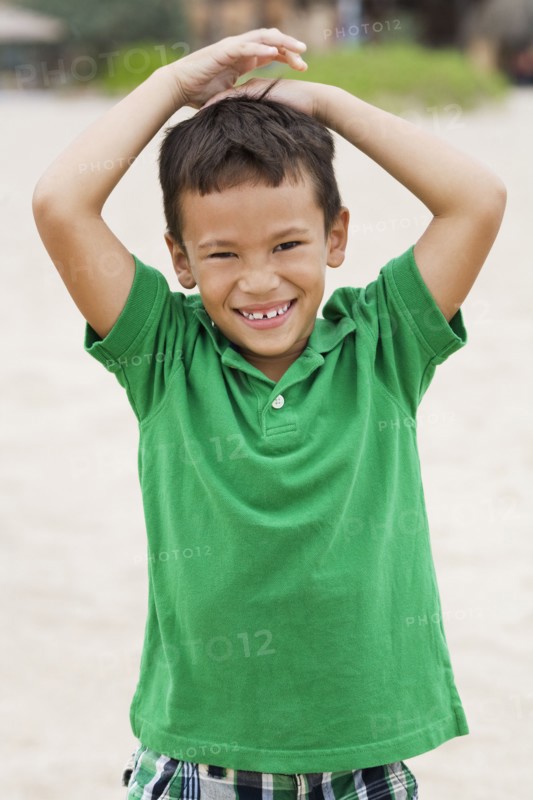 Mixed race boy smiling on beach