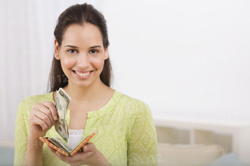 Hispanic woman removing money from wallet