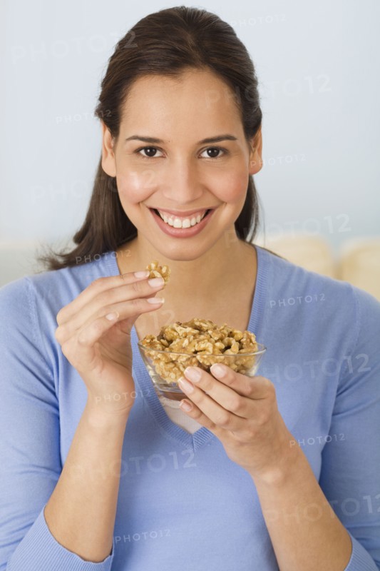 Hispanic woman eating walnuts