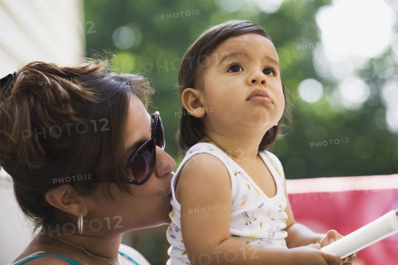 Hispanic mother kissing baby boy
