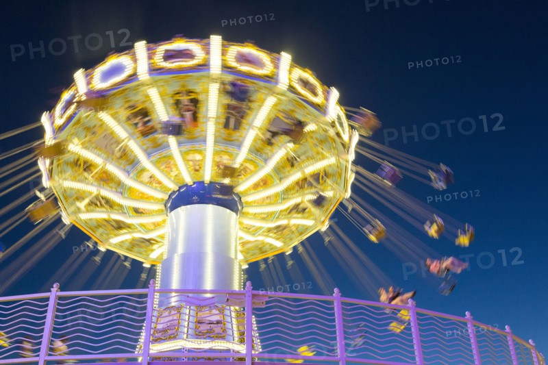 Illuminated spinning amusement park ride at night